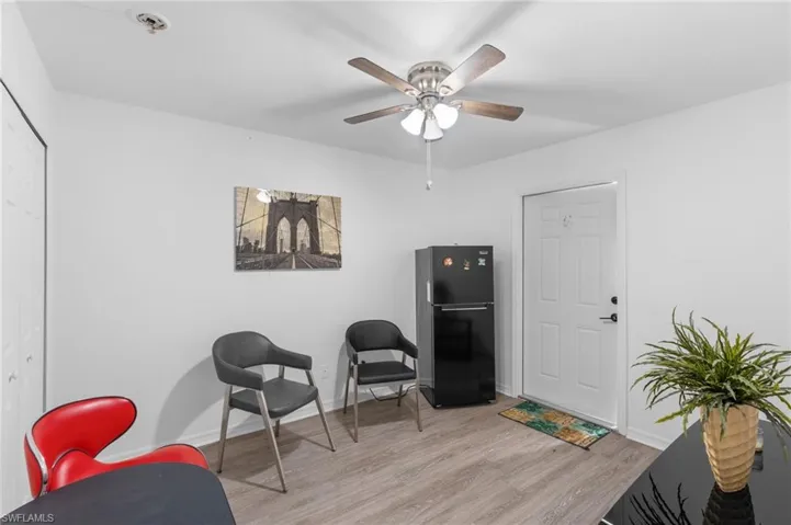 Living area with light hardwood / wood-style floors and ceiling fan