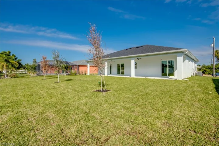 Back of property featuring a patio, a yard, stucco siding, and ceiling fan