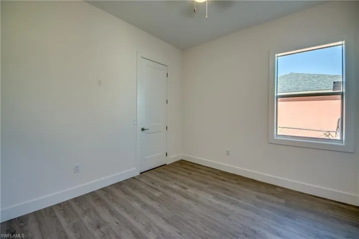 Spare room featuring baseboards and wood finished floors