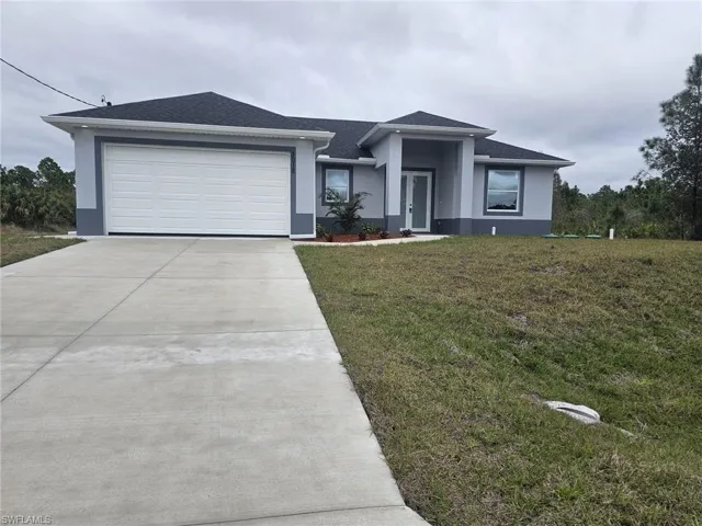 View of front of home with a garage and a front yard