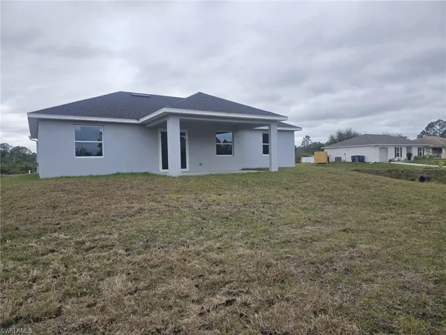 Back of house with a lawn