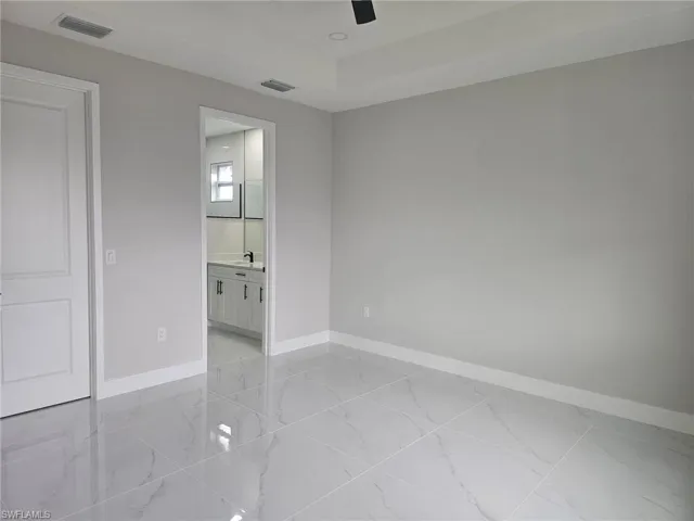 Unfurnished bedroom with sink, ceiling fan, and ensuite bath