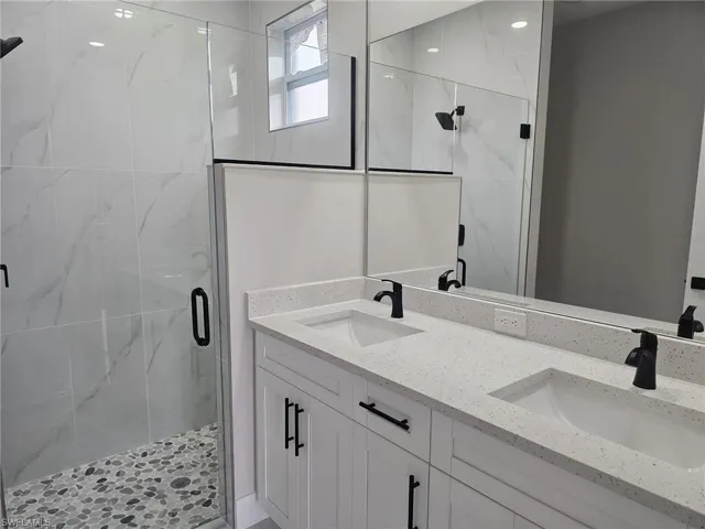 Bathroom with a shower with door and vanity
