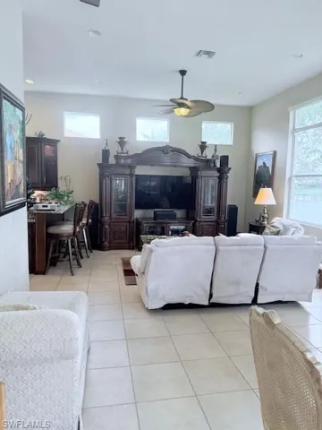 Living room with light tile patterned flooring, ceiling fan, and recessed lighting