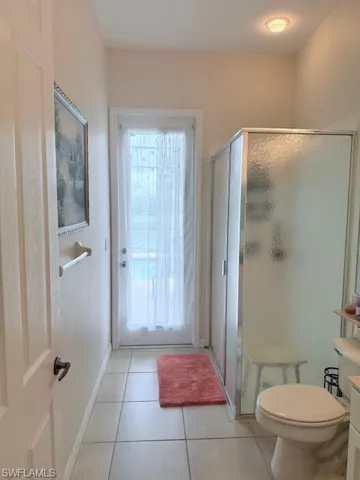 Full bath with tile patterned floors, a shower stall, and vanity