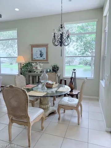 Dining area with a chandelier, light tile patterned floors, healthy amount of natural light, and recessed lighting