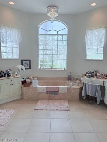 Bathroom with a garden tub, recessed lighting, vanity, and tile patterned floors