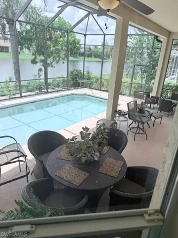 Outdoor pool featuring a water view, a patio, and a lanai