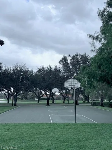 View of basketball court featuring a lawn and community basketball court