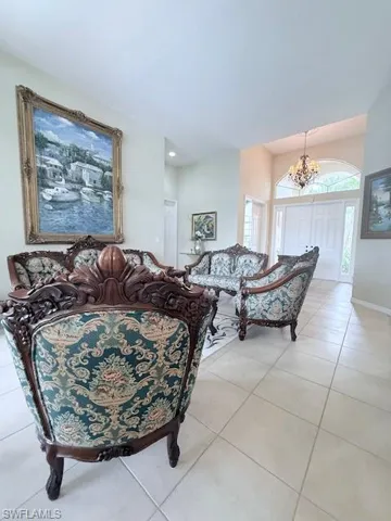 Living room with light tile patterned flooring and a chandelier