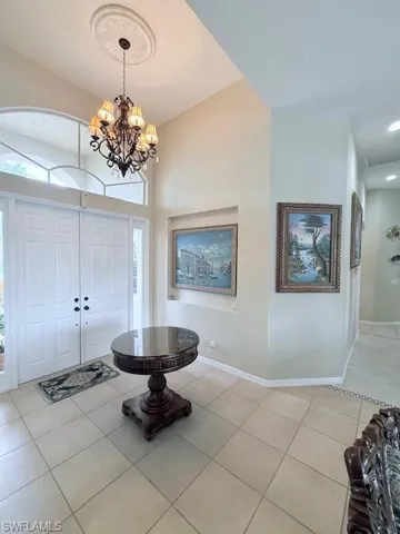 Foyer featuring light tile patterned flooring and a chandelier