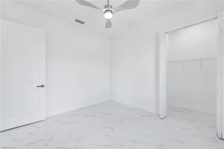 Unfurnished bedroom featuring ceiling fan, a closet, and light tile flooring