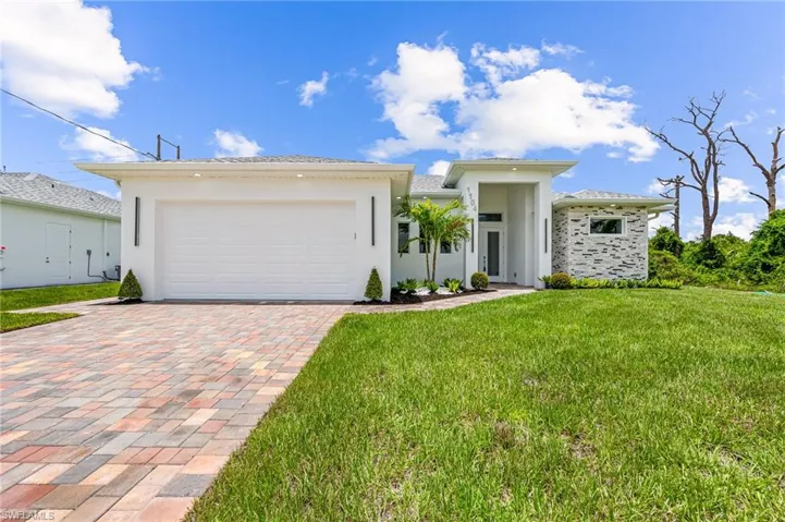 View of front of house featuring a garage and a front yard