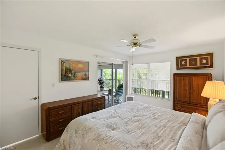 Bedroom with access to exterior, a ceiling fan, carpet, and a textured ceiling