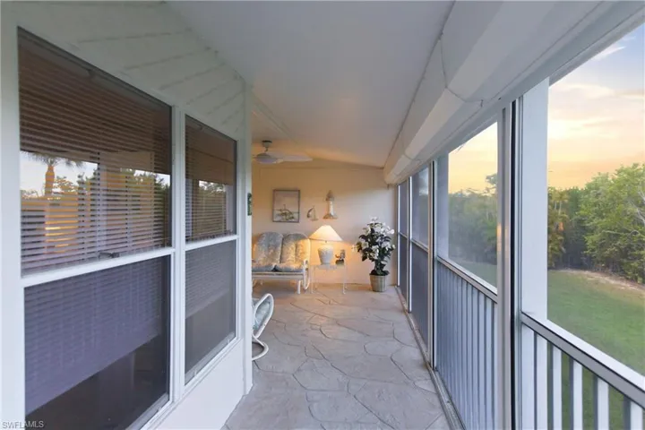 Sunroom featuring stone flooring, ceiling fan, and vaulted ceiling