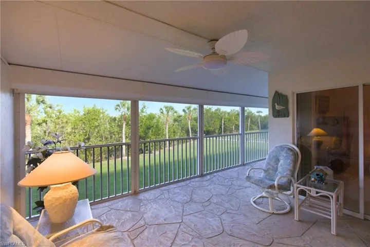 Sunroom featuring stone floors and view of scattered trees