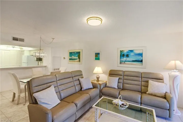 Living room with a textured ceiling, a chandelier, and tile patterned flooring