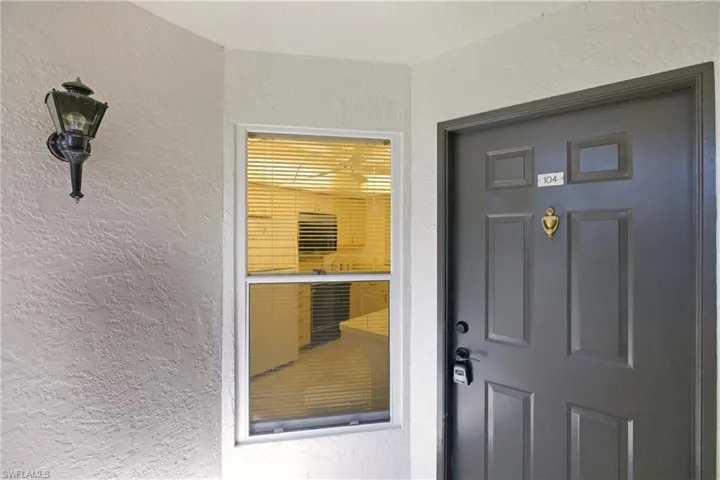 Doorway to property featuring stucco siding