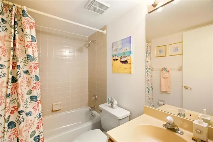 Bathroom featuring shower / bathtub combination with curtain and vanity