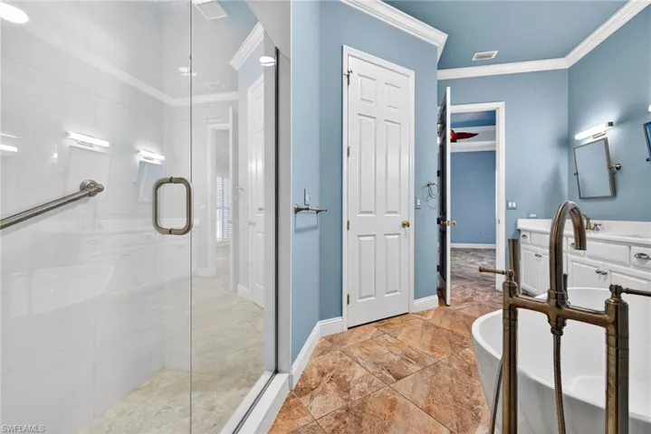 Full bathroom with a stall shower, ornamental molding, a soaking tub, and vanity
