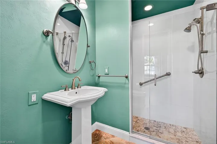 Full bath featuring a stall shower and a textured wall