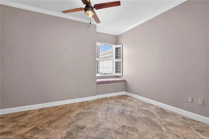 Spare room featuring ornamental molding and a ceiling fan