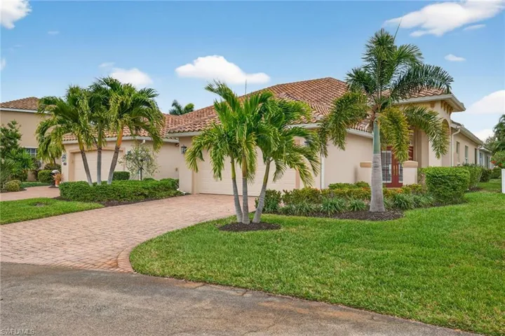 Mediterranean / spanish house with stucco siding, a front yard, decorative driveway, and a tiled roof