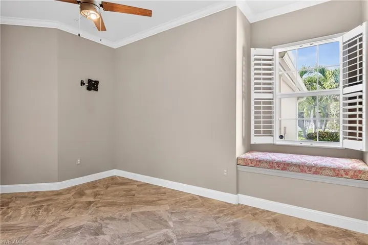 Empty room featuring crown molding and ceiling fan