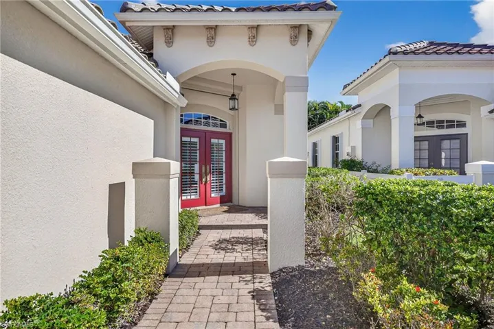 View of exterior entry featuring french doors, stucco siding, and a tiled roof