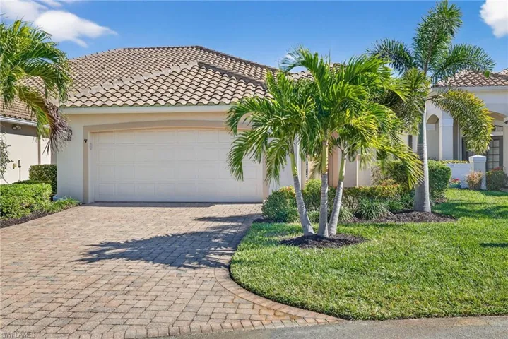 Mediterranean / spanish-style house with decorative driveway, stucco siding, an attached garage, and a tiled roof