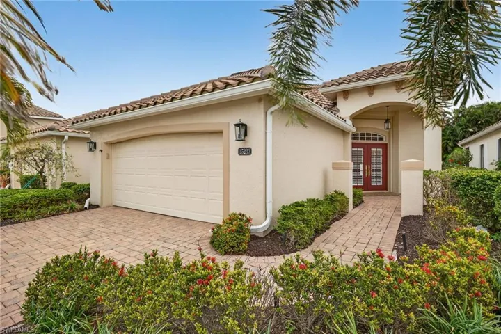 Mediterranean / spanish home with french doors, stucco siding, driveway, a tiled roof, and an attached garage