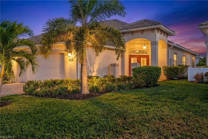 Mediterranean / spanish-style house featuring stucco siding, french doors, a garage, a yard, and driveway