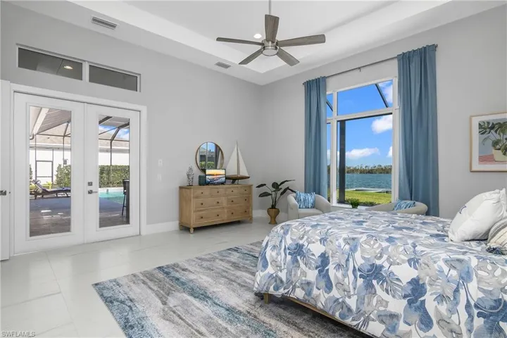 Bedroom featuring access to outside, french doors, a water view, ceiling fan, and light tile patterned floors