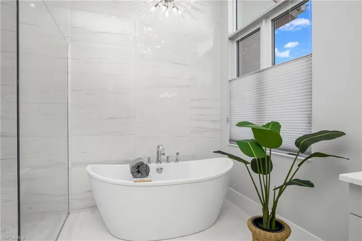 Bathroom with a tub to relax in and tile walls