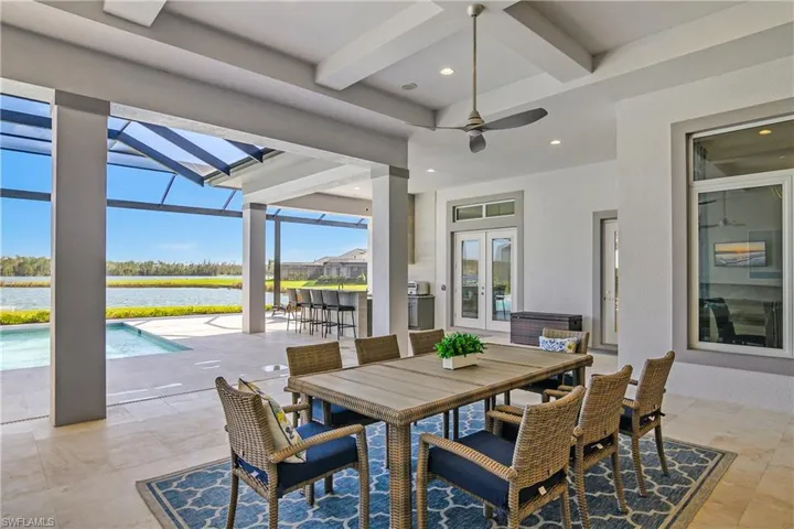 View of patio / terrace with ceiling fan, a lanai, a water view, and french doors