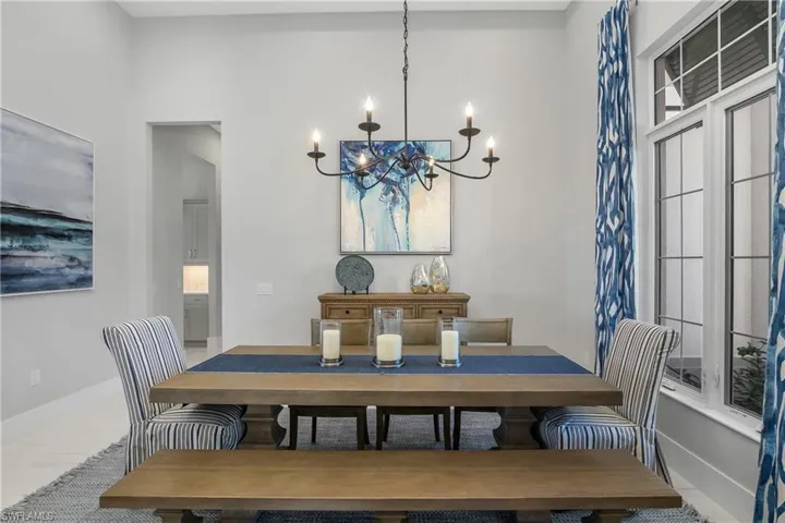 Dining area with tile patterned floors and an inviting chandelier