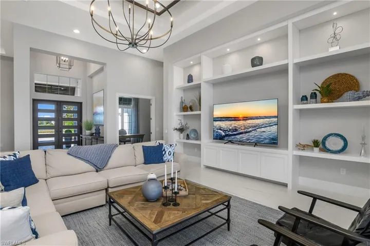 Custom feature wall with built-in lighted bookshelves and additional cabinetry.