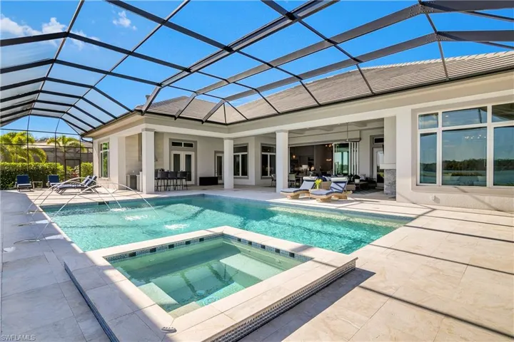 View of swimming pool featuring a lanai, a patio area, and an in ground hot tub