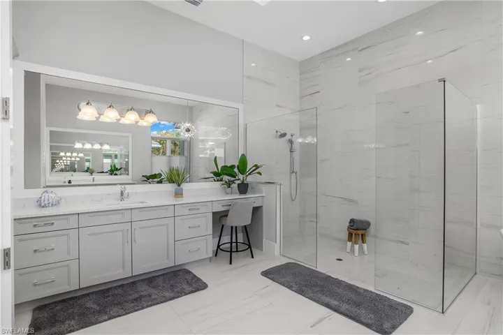 Bathroom featuring a tile shower and vanity