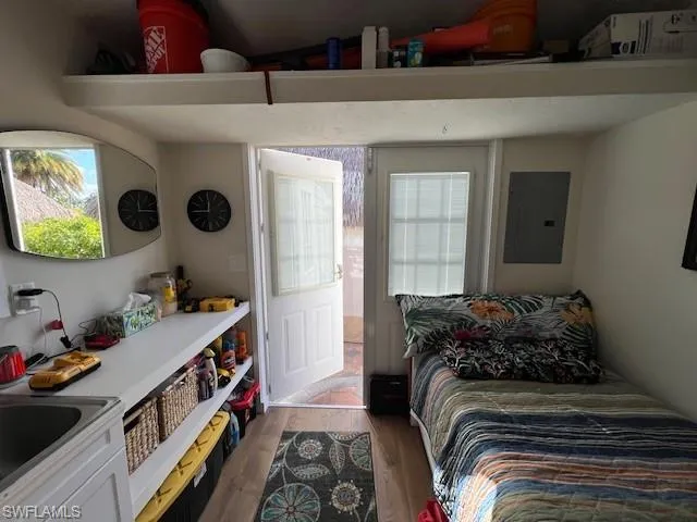 Bedroom featuring wood finished floors and electric panel