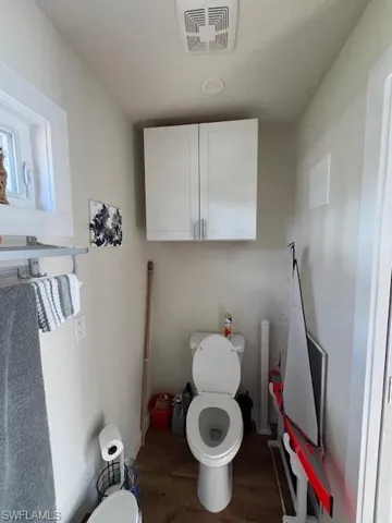 Bathroom featuring toilet, wood finished floors, and visible vents