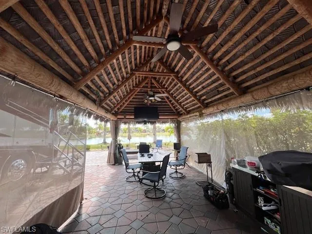 View of patio with a gazebo, outdoor dining space, and a ceiling fan
