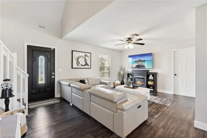 Living room with ceiling fan and dark hardwood / wood-style flooring
