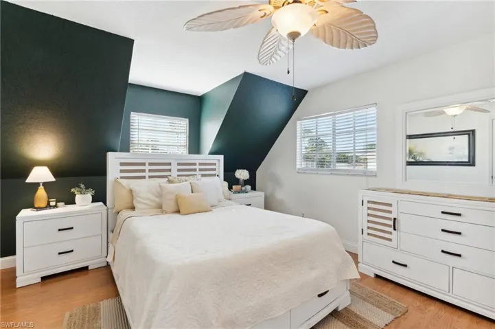 Bedroom featuring multiple windows, ceiling fan, and light wood-type flooring