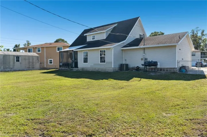 Back of house featuring a yard and a sunroom