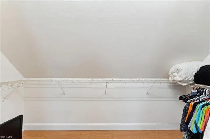 Spacious closet with light hardwood / wood-style flooring