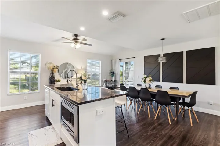 Kitchen featuring a healthy amount of sunlight, sink, pendant lighting, and a center island with sink