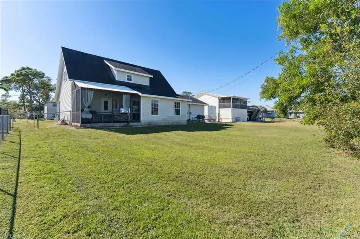 Back of property featuring a sunroom and a yard