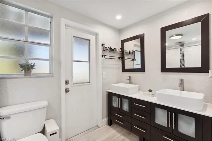 Bathroom featuring vanity, hardwood / wood-style flooring, and toilet