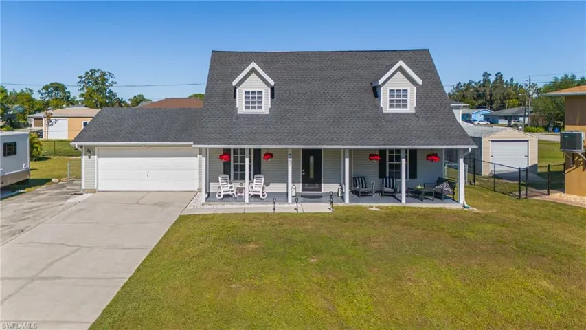 View of front of property with cooling unit, a porch, and a front yard